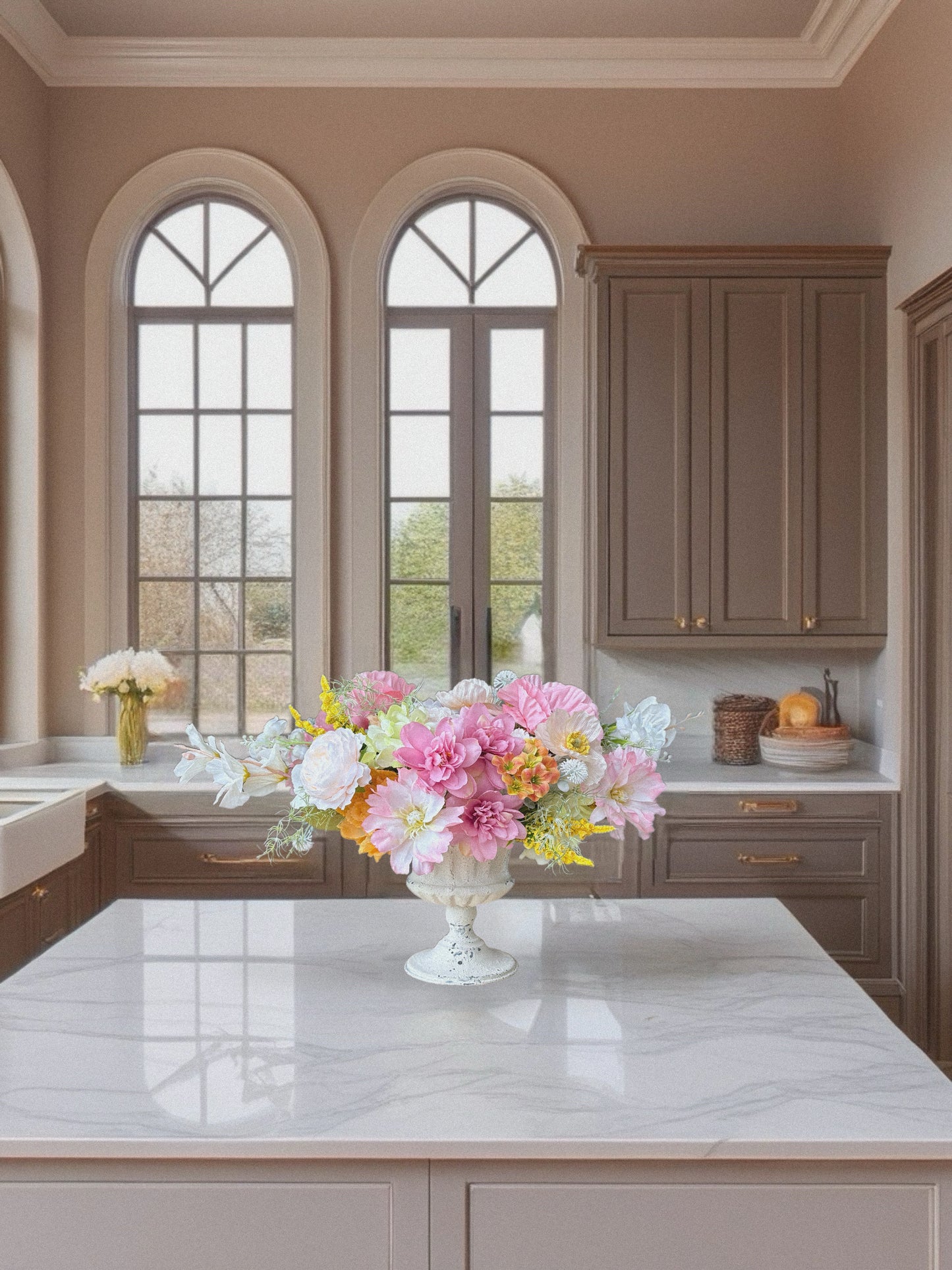 Modern kitchen with marble island, cabinets, and decorative flowers.