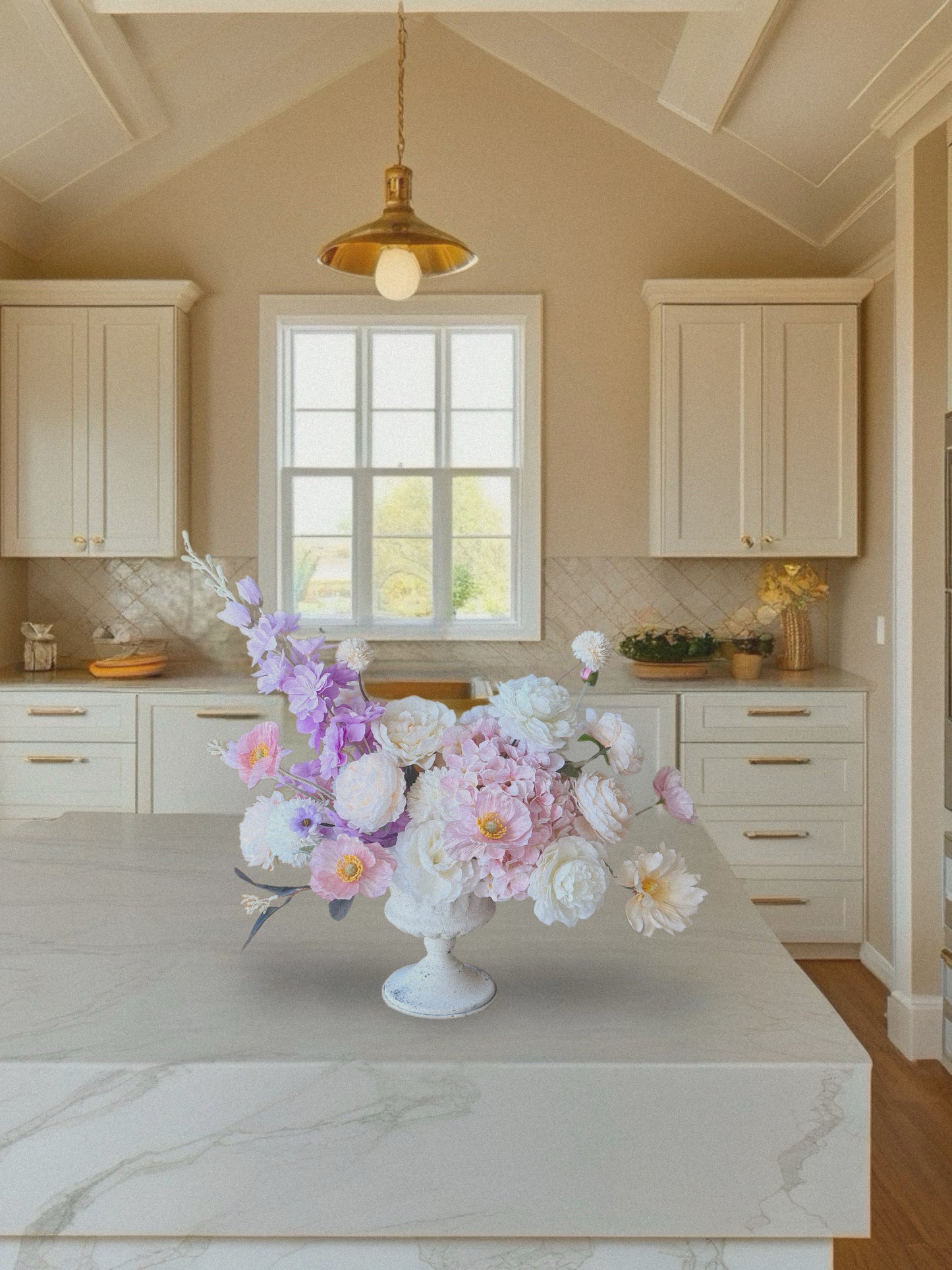 Floral arrangement on a kitchen counter with light-colored cabinets and a window in the background.