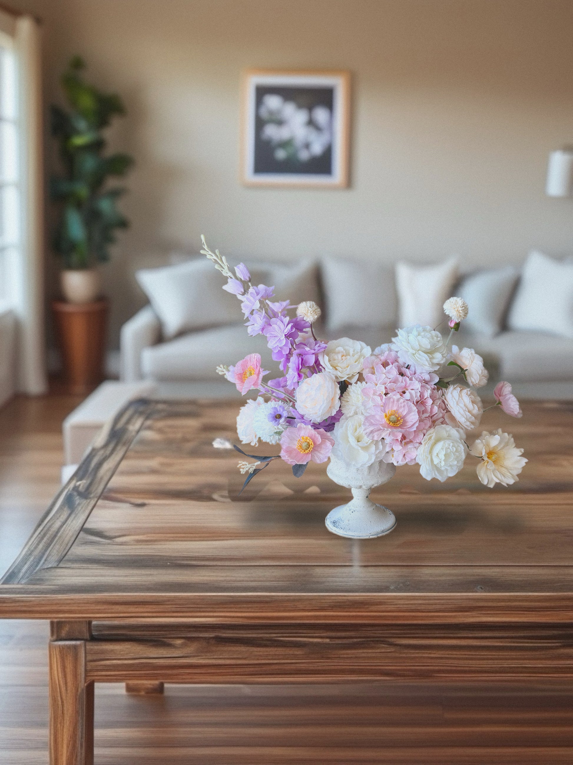 Floral arrangement on a wooden coffee table in a living room setting