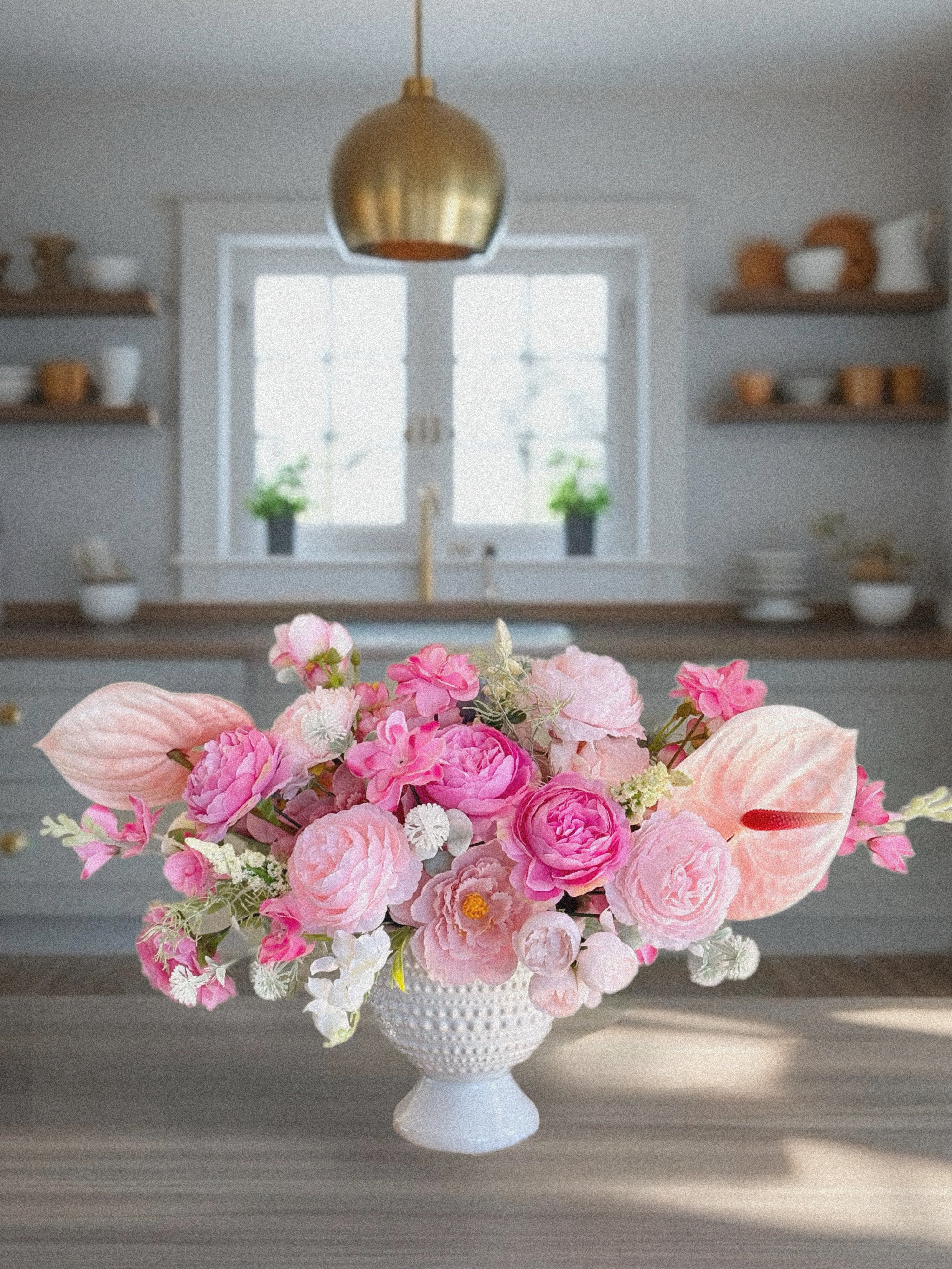 Pink romantic style bouquet with peonies and roses in a ceramic vase