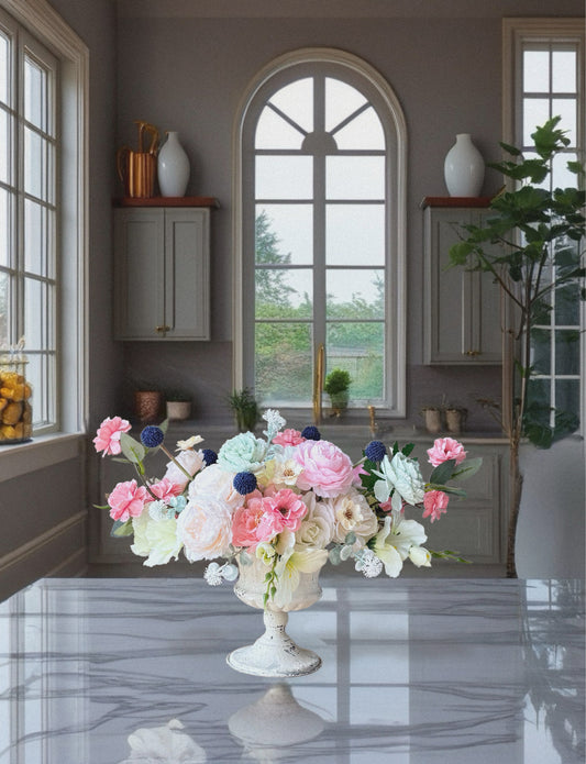 Floral arrangement on a table in a room with large windows and shelves.