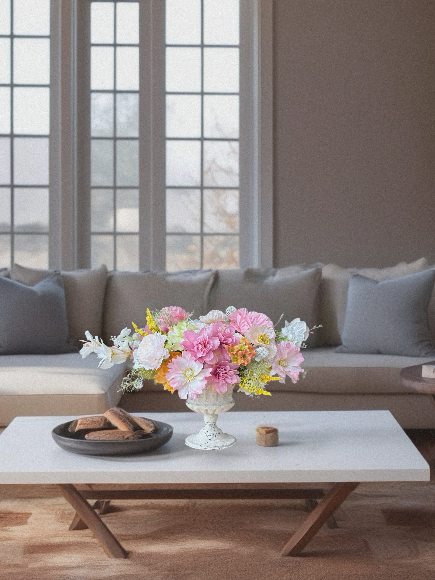Living room with a sofa, coffee table, and decorative flowers.