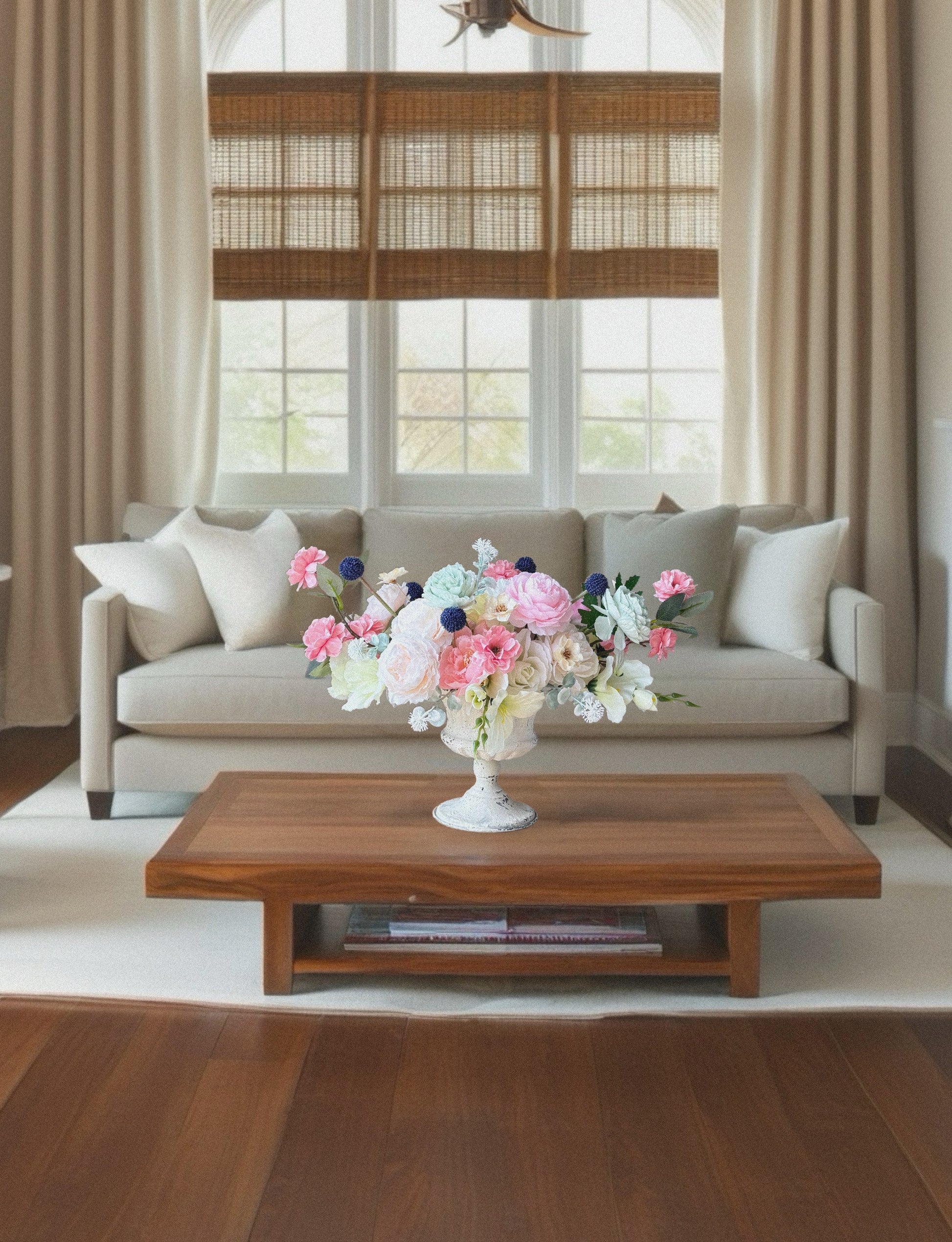 Living room with a beige sofa, wooden coffee table, and floral arrangement.
