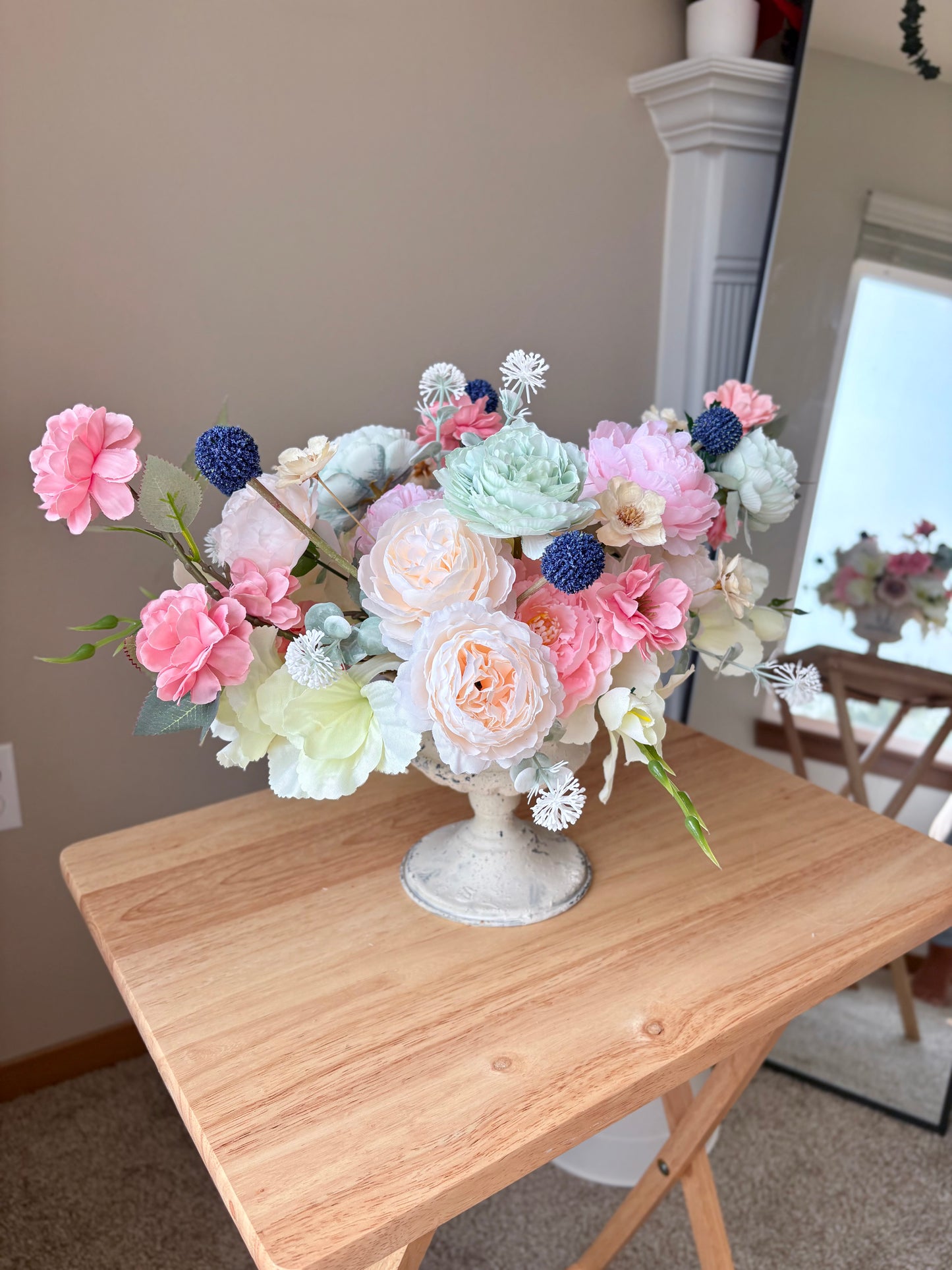Bouquet of flowers in a decorative vase on a wooden table.