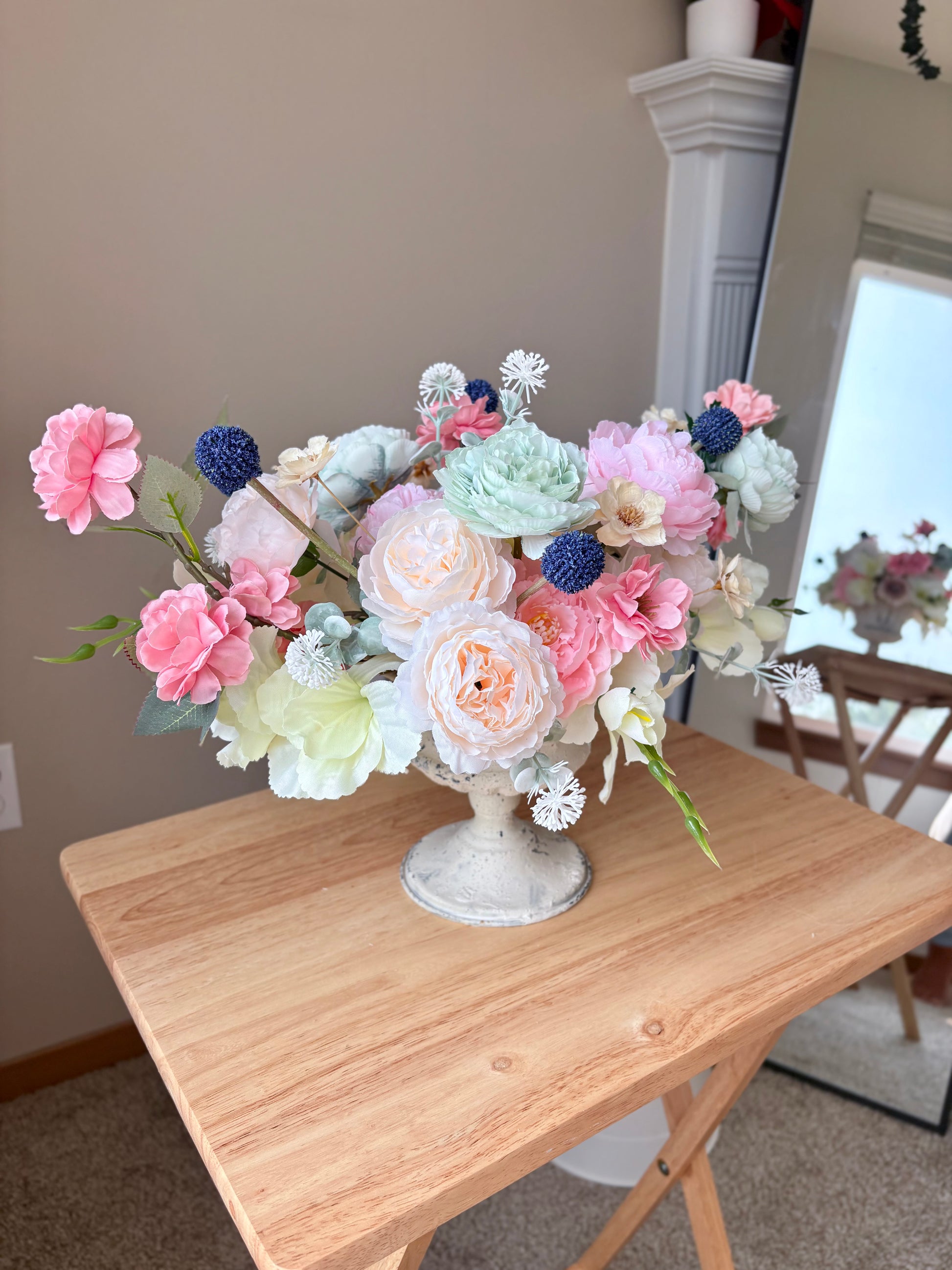 Bouquet of flowers in a decorative vase on a wooden table.