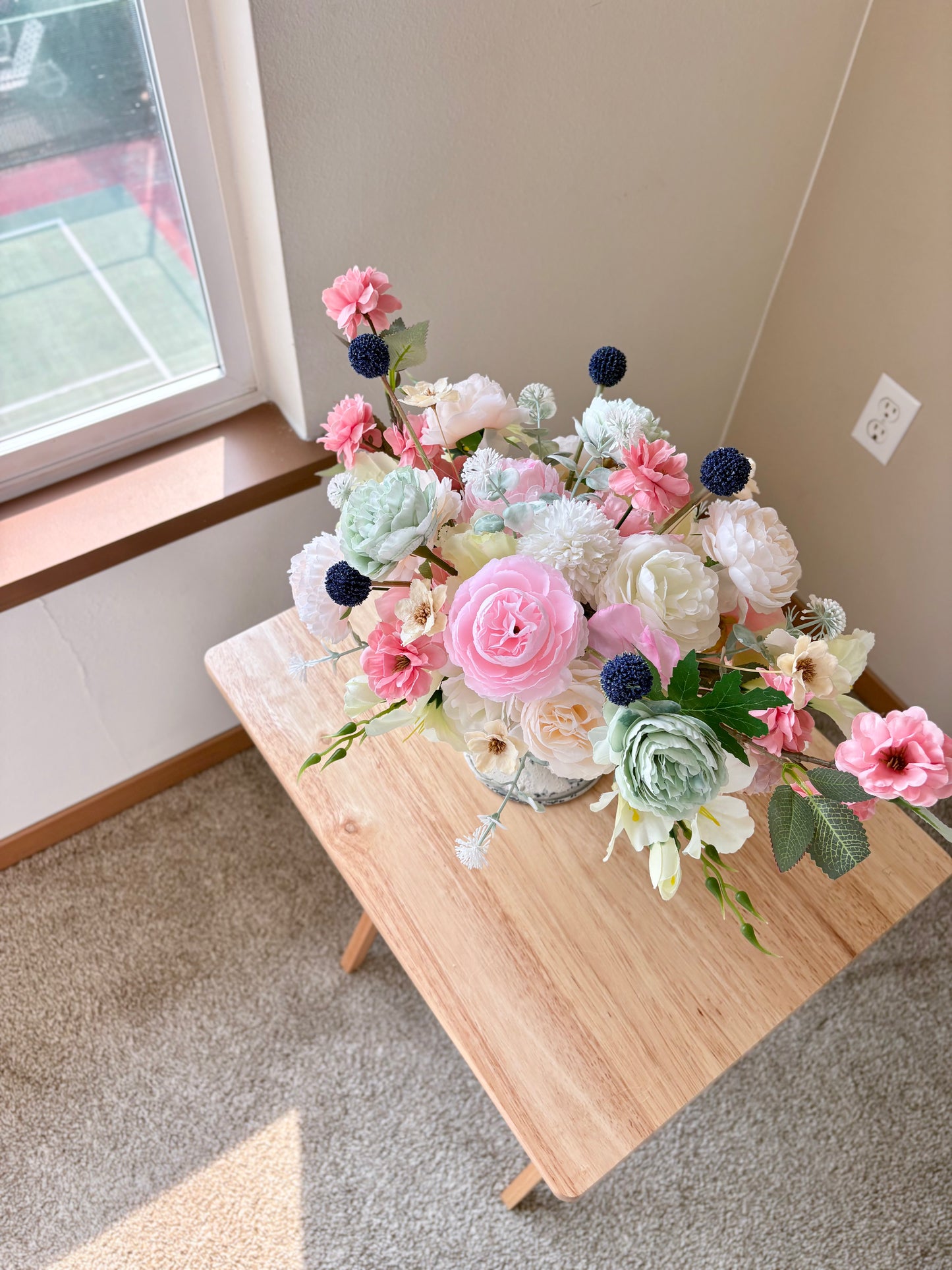 Bouquet of flowers on a wooden table near a window