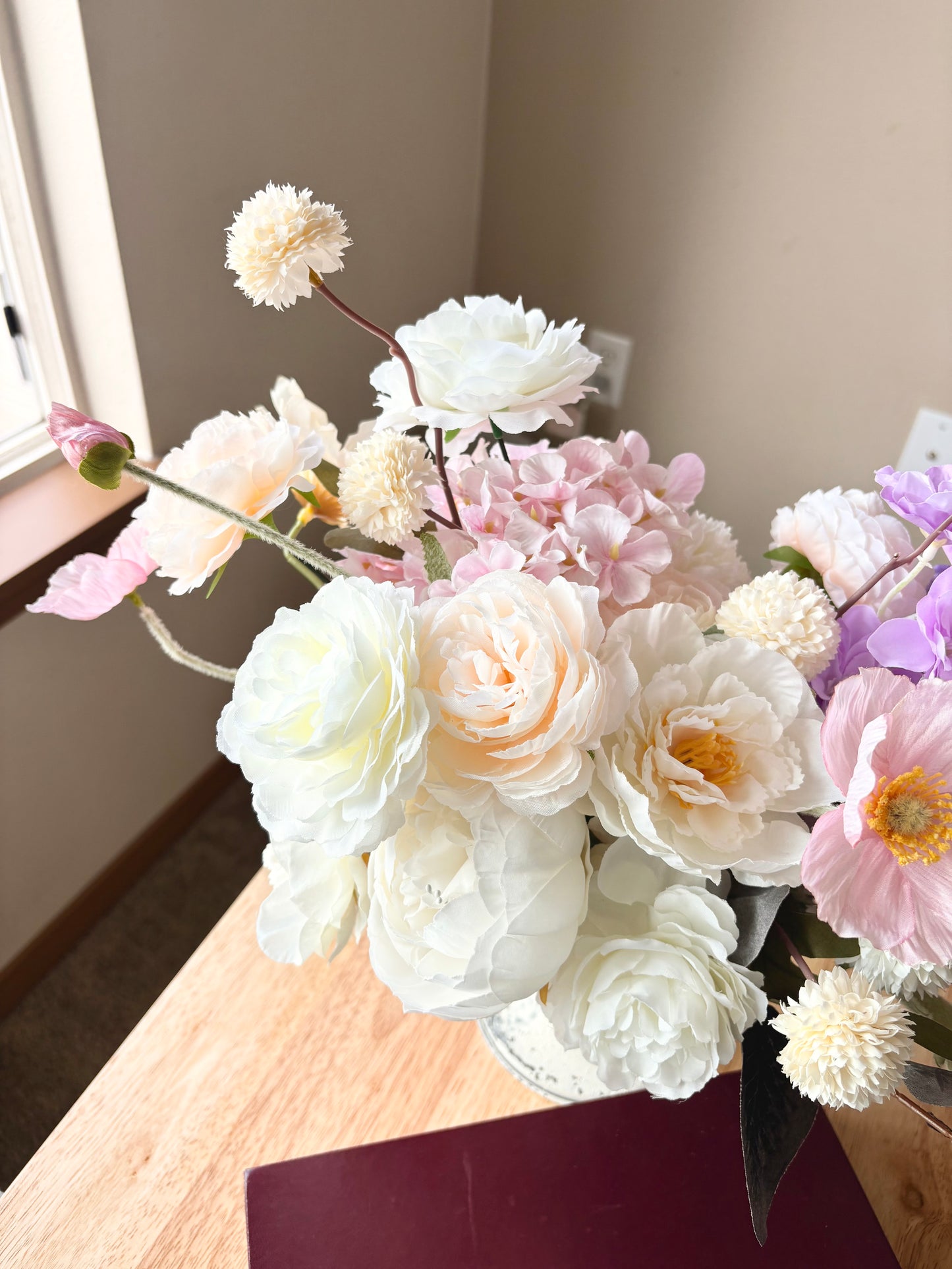 Bouquet of flowers on a wooden surface with a neutral background
