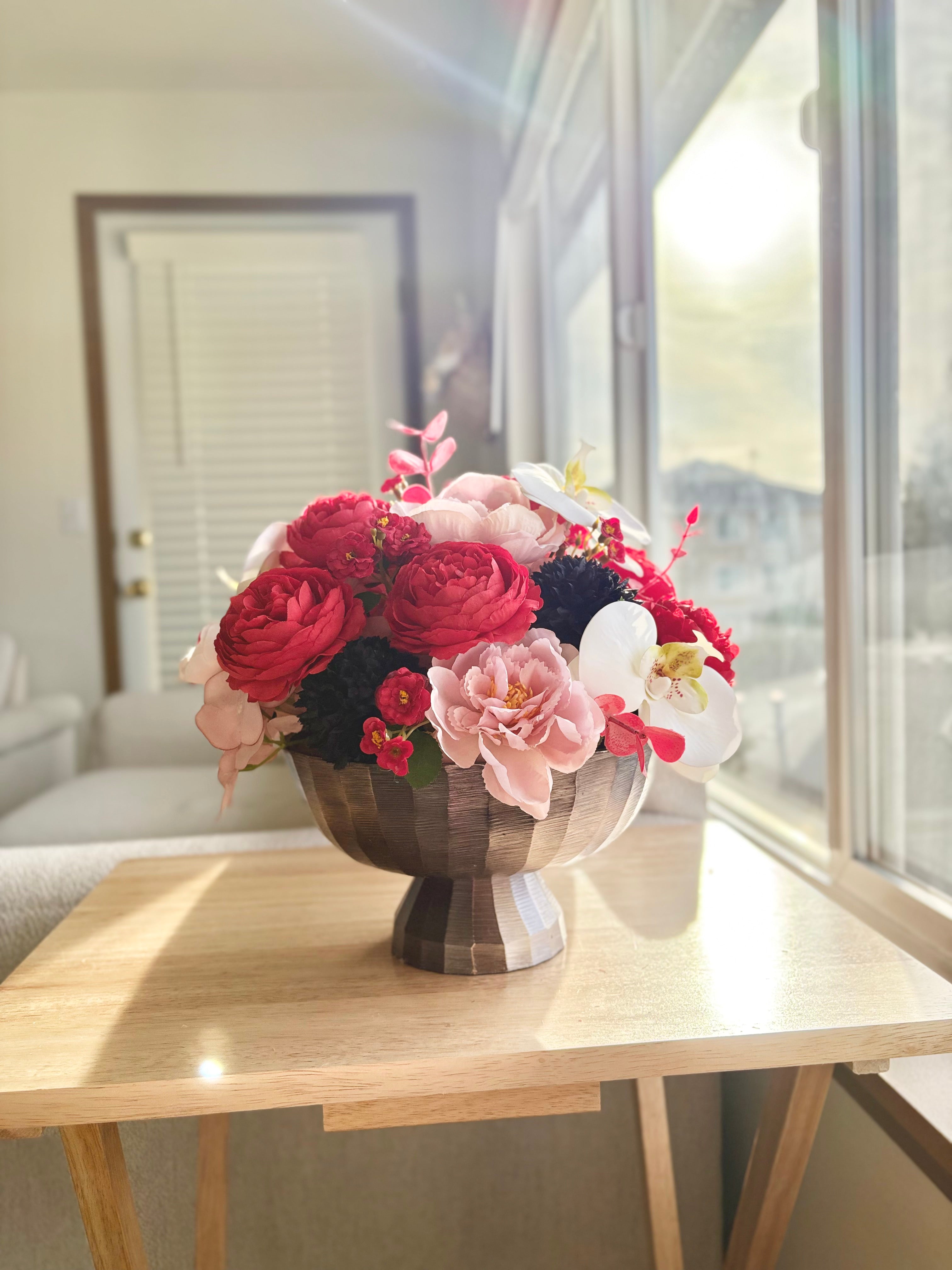 Floral arrangement in a vase on a table near a window