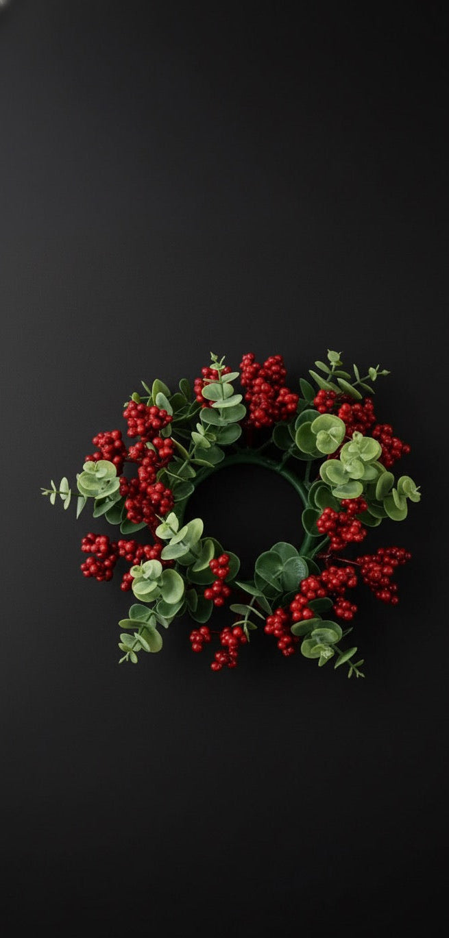 Decorative wreath with red berries and green leaves on a black background