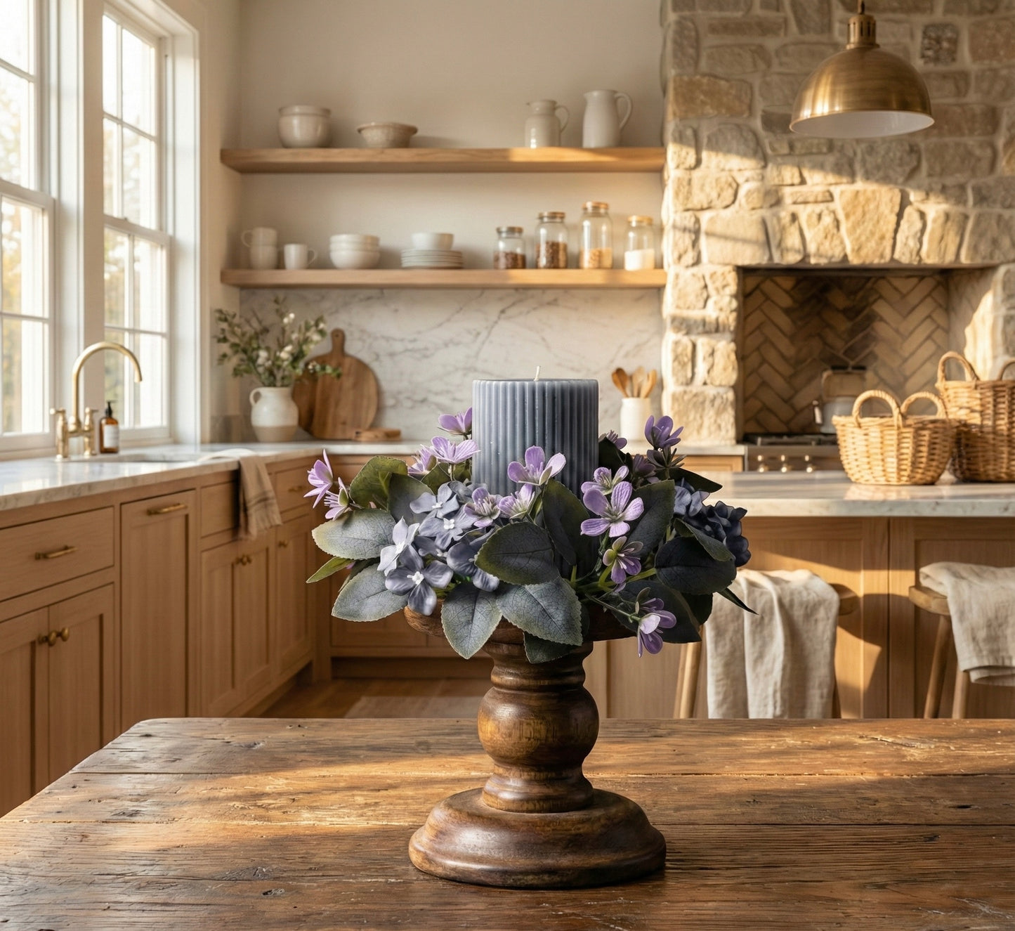 Decorative floral arrangement on a wooden table in a kitchen with stone walls and wooden shelves.