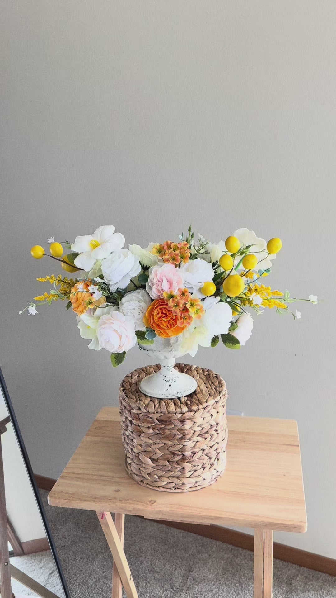 Elegant artificial flower arrangement in a white vase with a mix of white roses, peonies, and delicate orange blossoms accented with bright yellow details. This timeless centerpiece is perfect for year-round home decor, dining table decoration, or as a cheerful gift. Handmade from high-quality faux flowers, it looks realistic, stays fresh all year long, and requires no maintenance. A lovely accent for farmhouse, rustic, or modern interiors.
